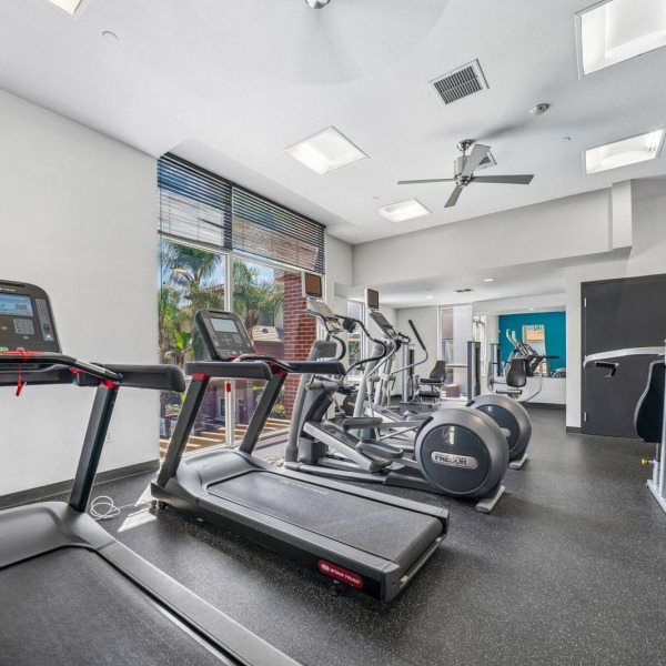 Cardio area at Ontario Town Square Townhomes in Ontario, California, with treadmills fronting the weight-training equipment.