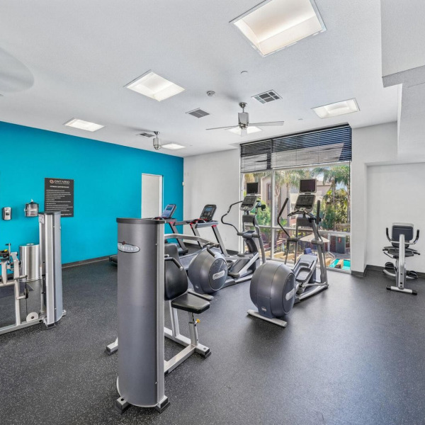The 24-hour fitness center at Ontario Town Square Townhomes in Ontario, California, with cardio machines and strength equipment.