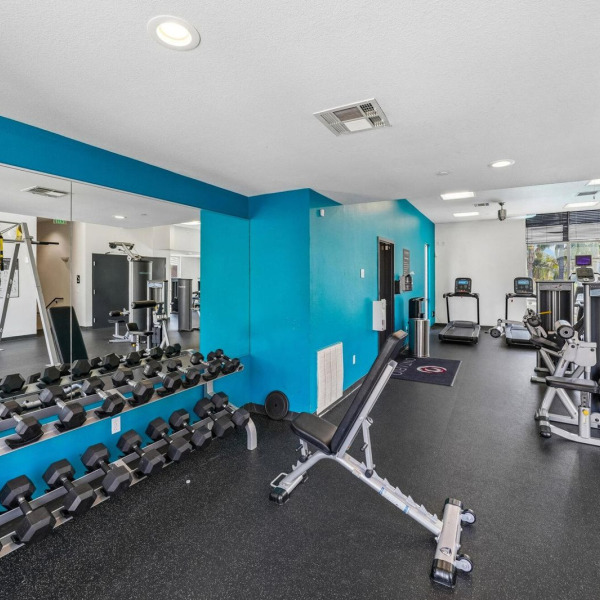 Free-weight area at Ontario Town Square Townhomes in Ontario, California, with a full dumbbell rack and adjustable bench.