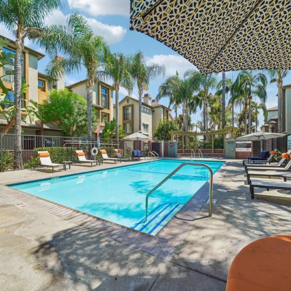 Sun loungers along the swimming pool at Ontario Town Square Townhomes in Ontario, California.