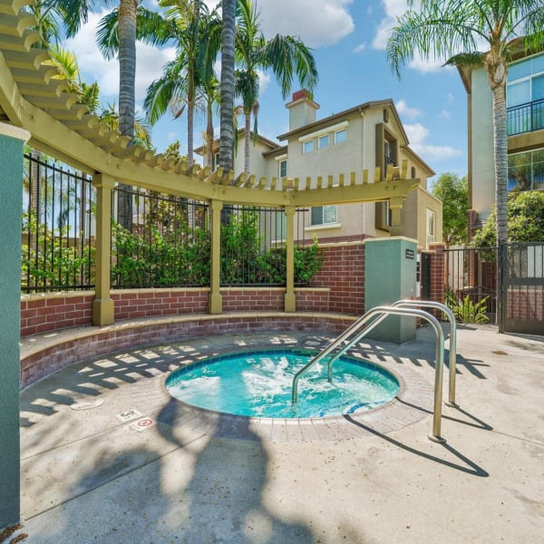 Resident spa at Ontario Town Square Townhomes in Ontario, California, set beneath a wood pergola surrounded by palms.