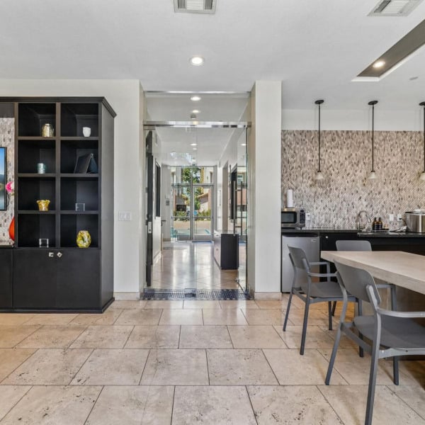 Complimentary coffee bar at Ontario Town Square Townhomes in Ontario, CA, with a mosaic tile backsplash and pendant lighting.