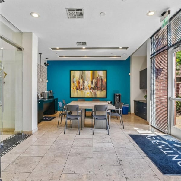 Clubhouse entrance at Ontario Town Square Townhomes in Ontario, California, with double glass doors and a bright, open interior.