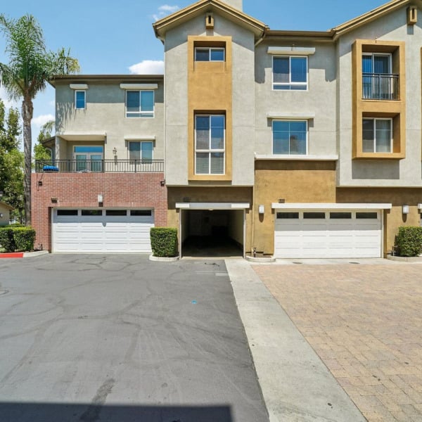 Three-story townhome building at Ontario Town Square Townhomes in Ontario, California, with attached garages and balconies.