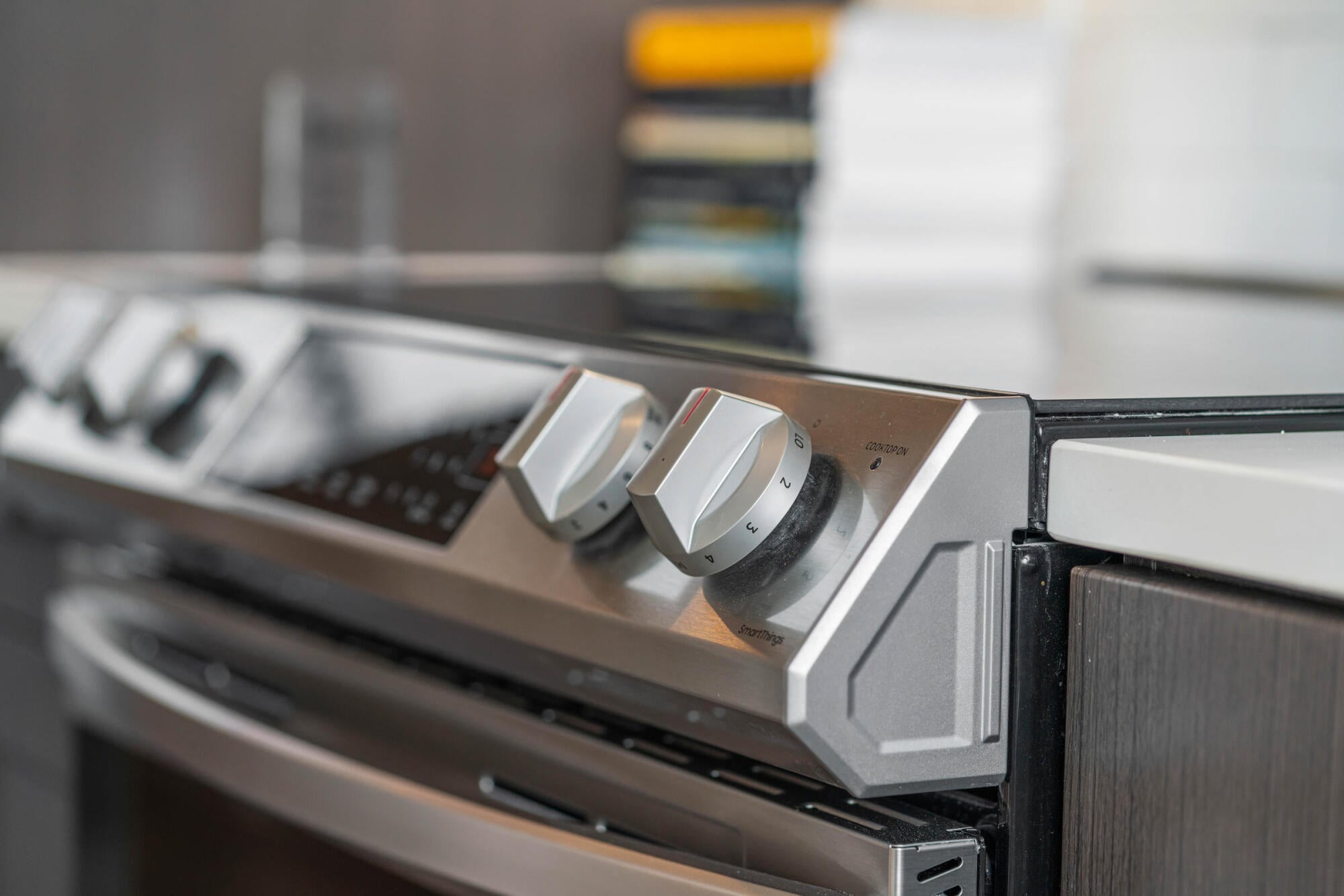 A close-up of the stainless steel range controls highlights the modern Samsung appliances found in every Jayne apartment kitchen in Denver, CO.