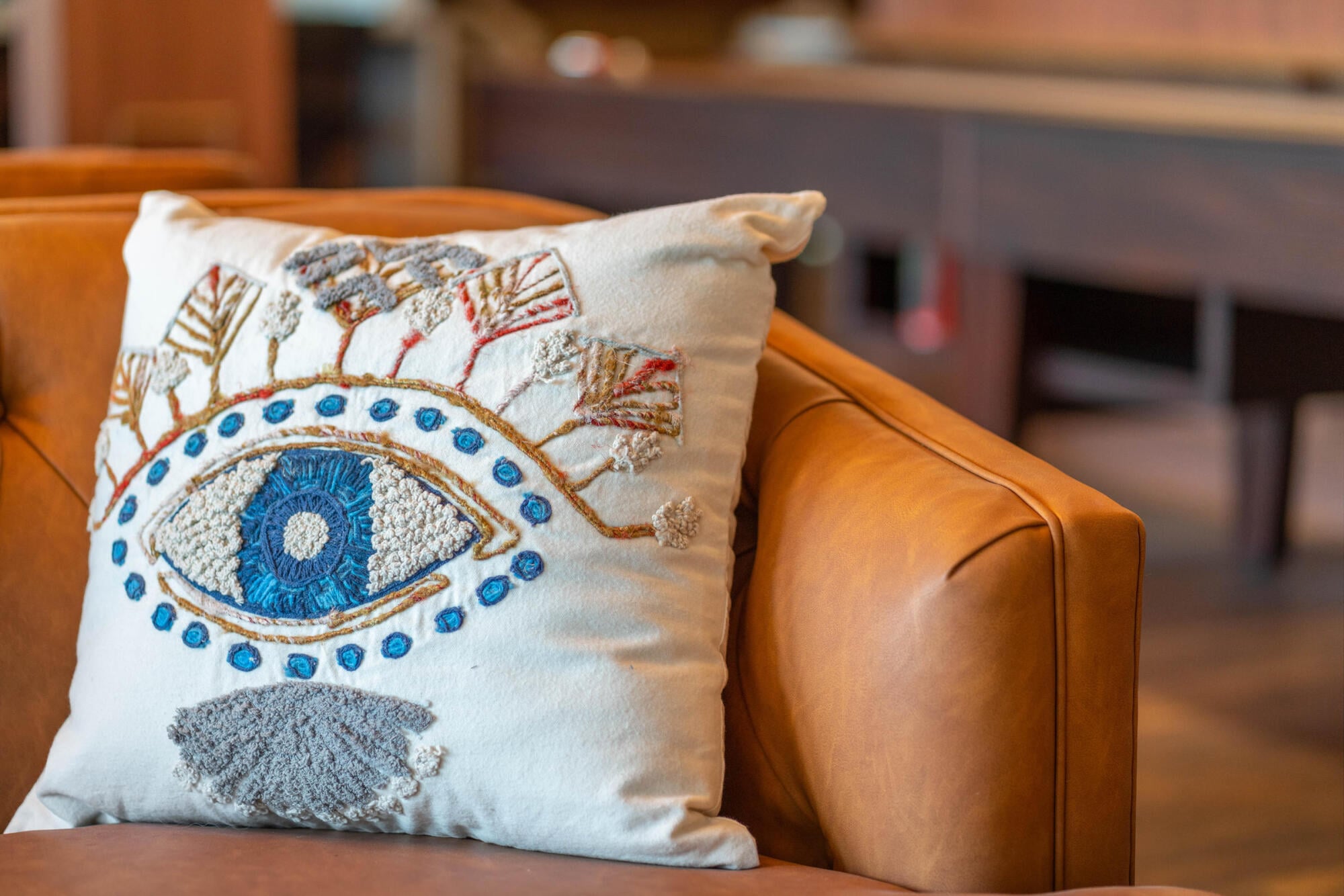 Playful eye-shaped throw pillows add a whimsical touch to the resident lounge seating at Jayne apartments in Denver, CO.