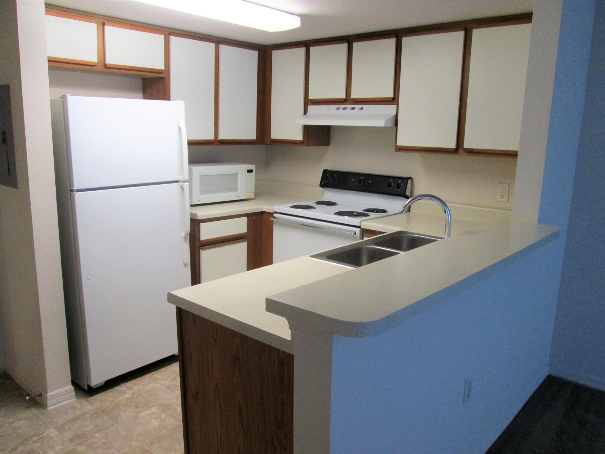 Kitchen with built-in microwave, range and ample cabinet storage at The Landings at Sea Forest in New Port Richey, FL.