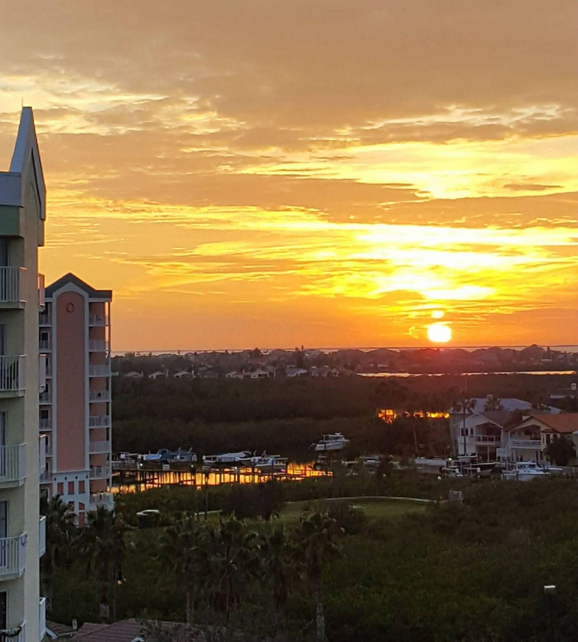 Golden Gulf sunset over the marina seen from The Landings at Sea Forest 55+ apartments in New Port Richey, FL.