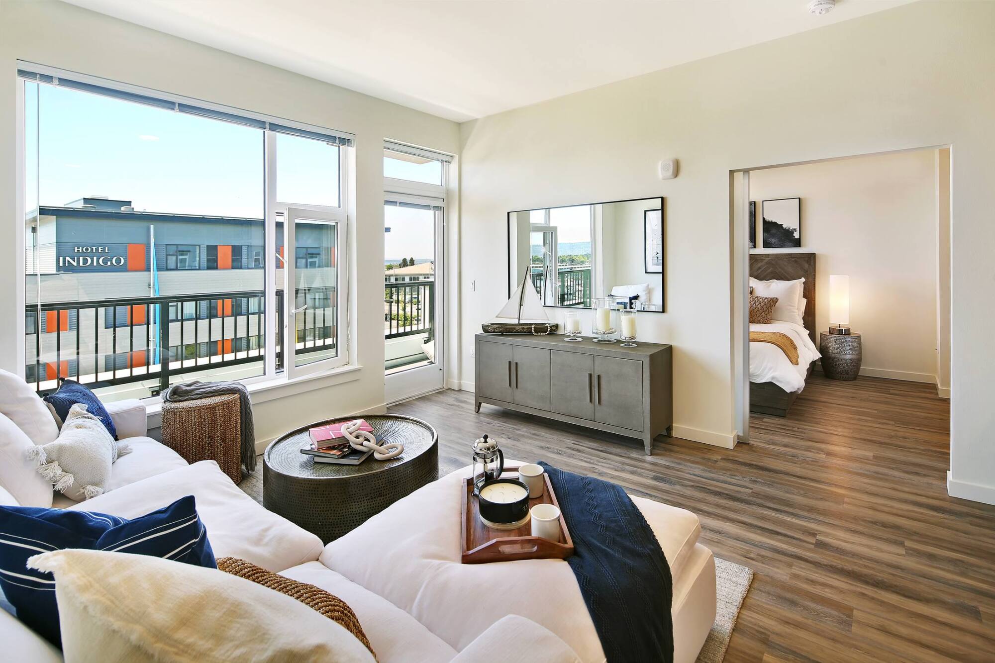 A furnished living room with a balcony and city view at Waterfront Place Apartments in Everett, WA.