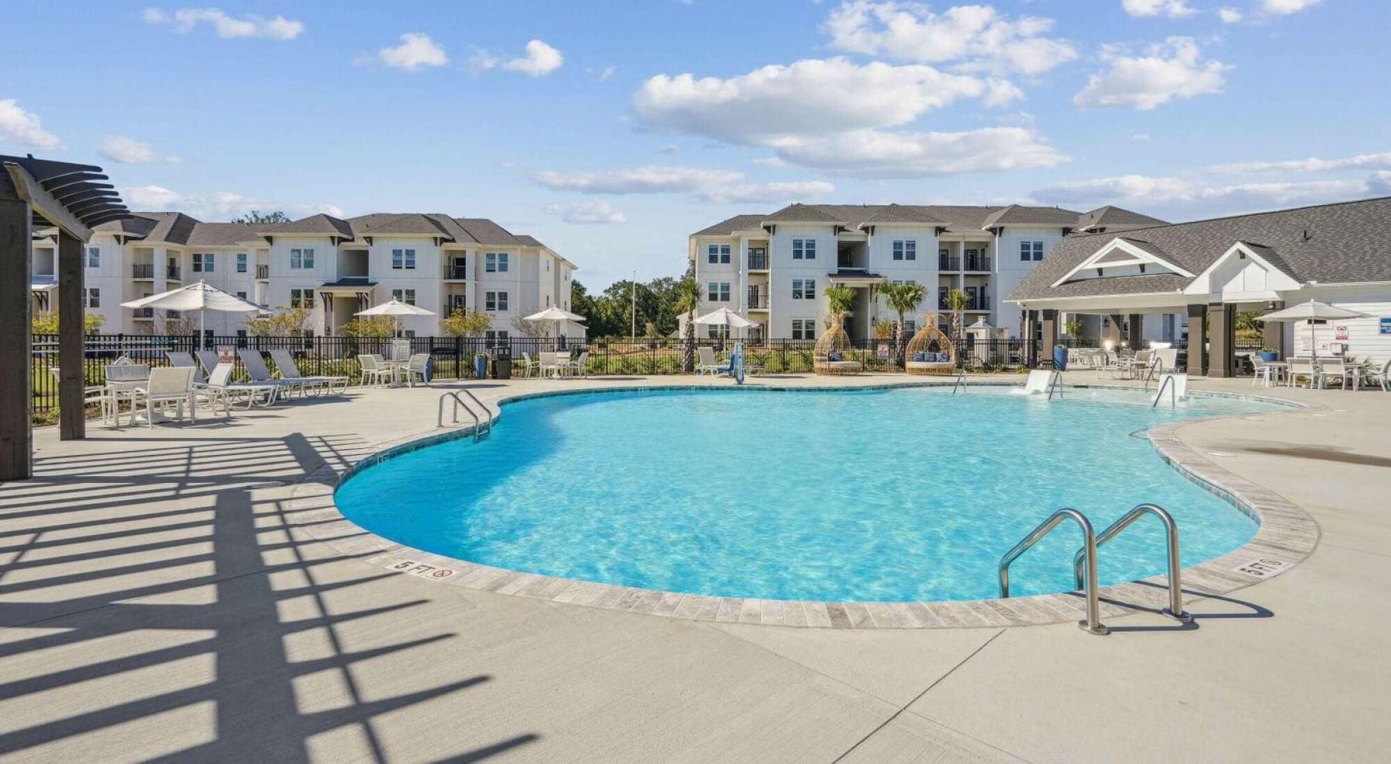A swimming pool in front of apartment buildings.