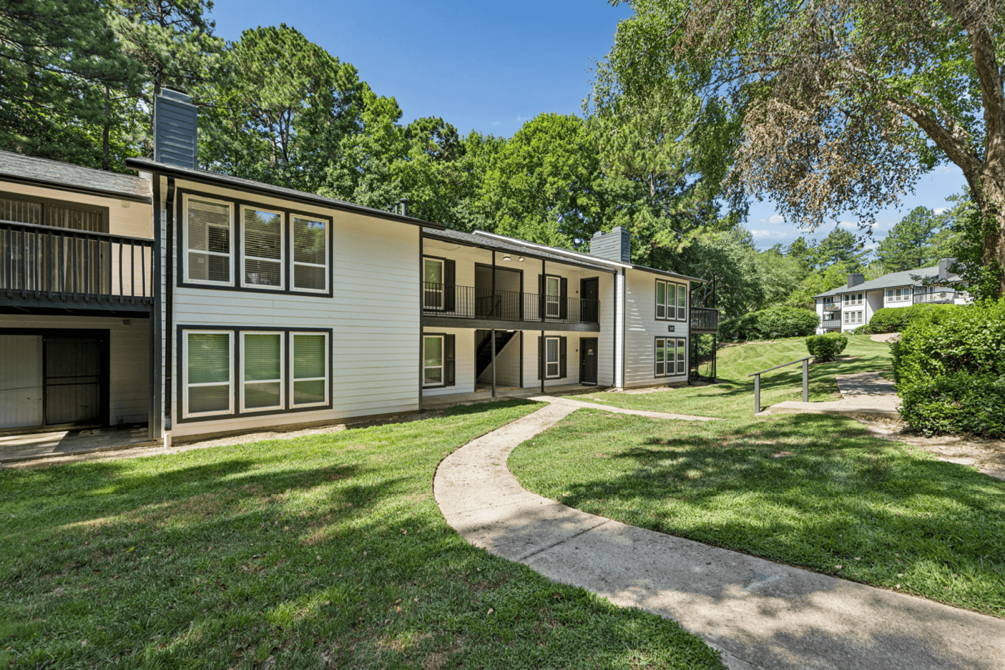 Apartment complex with a walkway in front.