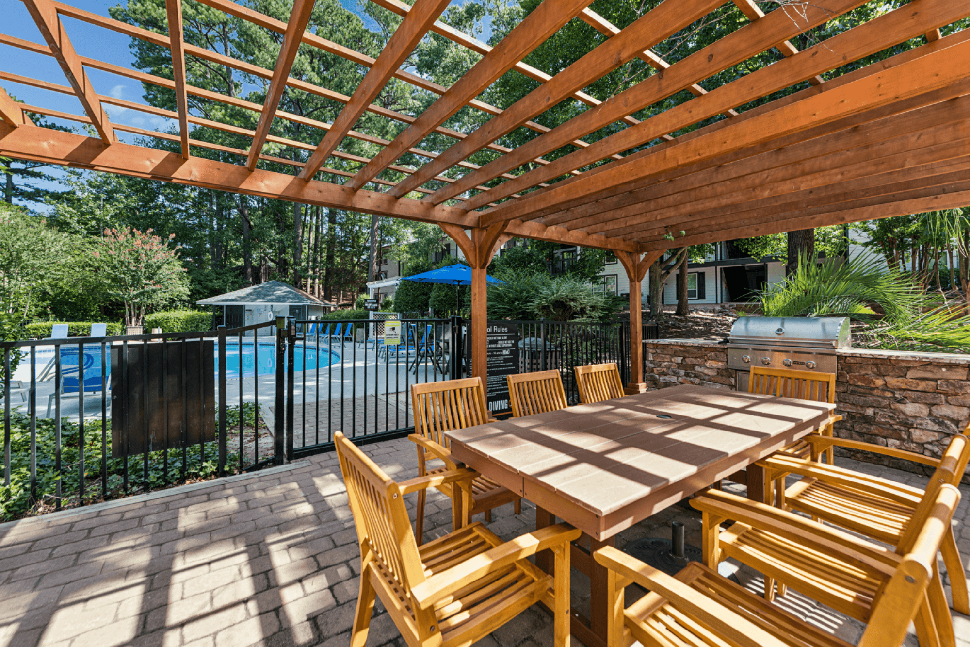 A wooden table and chairs are set up on a patio.