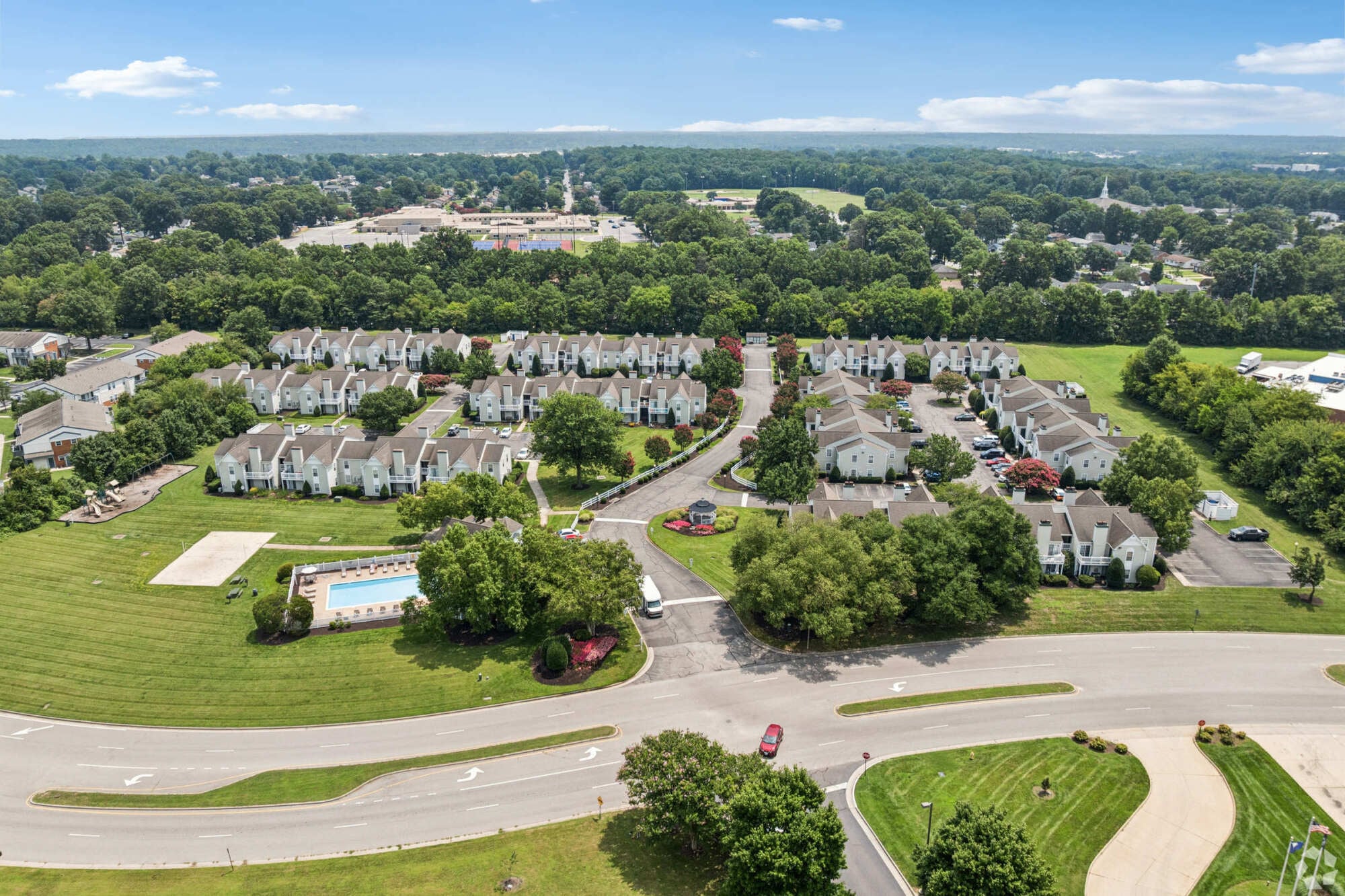 Oaks of Dunlop Farms in Colonial Heights, VA, aerial view of apartment buildings, landscaped grounds, parking areas, and the swimming pool.