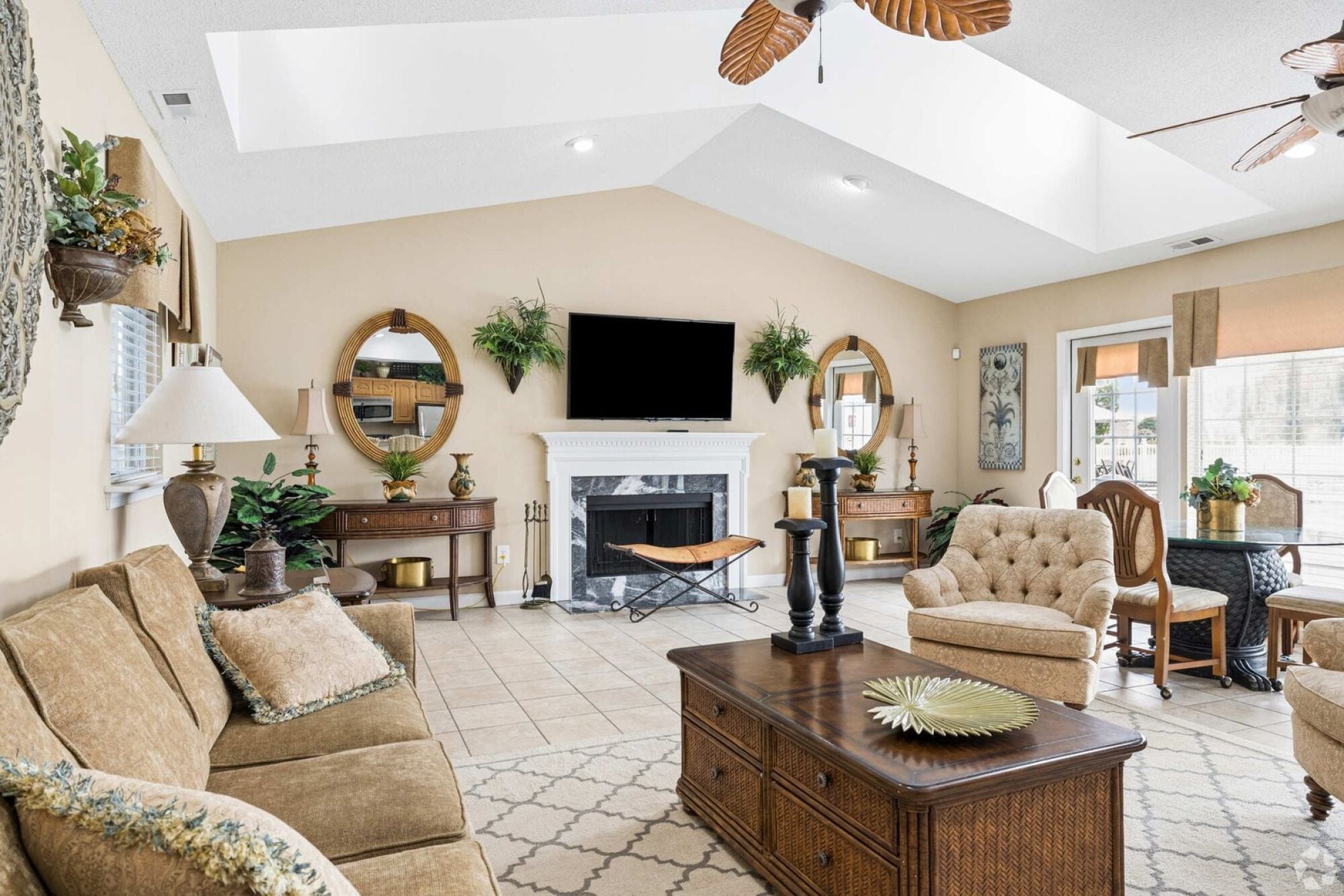Oaks of Dunlop Farms in Colonial Heights, VA, clubhouse lounge with sofas, a fireplace, television, and dining table.